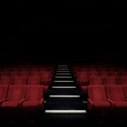 red cinema seats extending into the darkness
