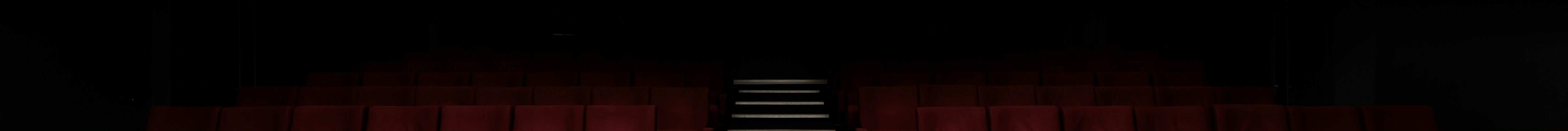 red cinema seats extending into the darkness